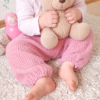 Sommerhose Willow uni aus Musselin getragen von sitzendem Kleinkind mit Teddy in der Hand